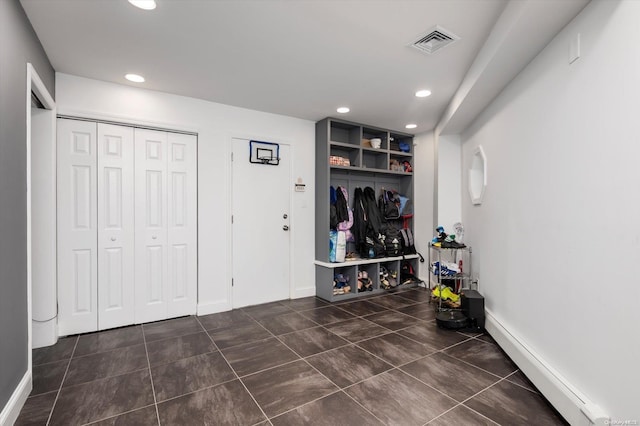 mudroom featuring built in shelves and a baseboard heating unit