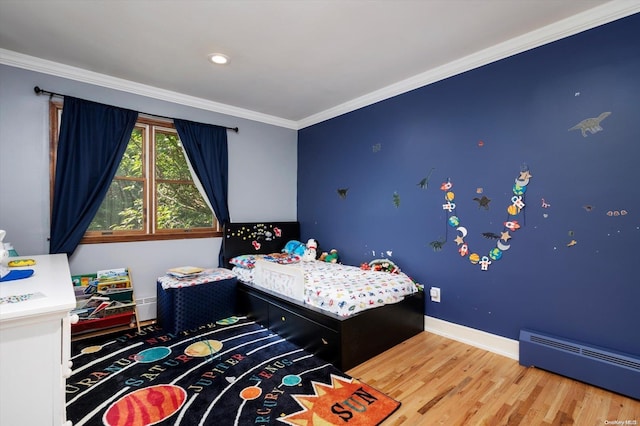 bedroom with hardwood / wood-style flooring, baseboard heating, and crown molding