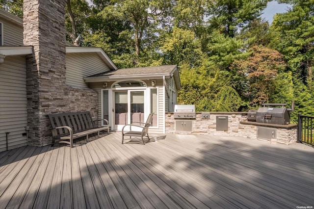 wooden terrace with an outdoor kitchen and area for grilling