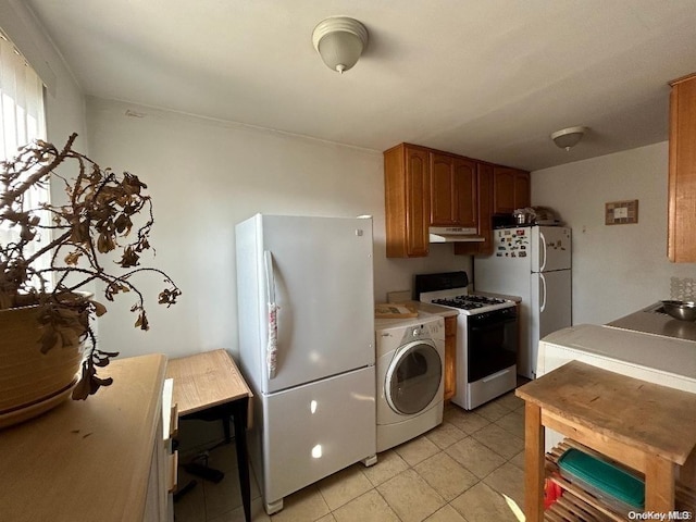 kitchen featuring washer / clothes dryer, light tile patterned floors, and white appliances