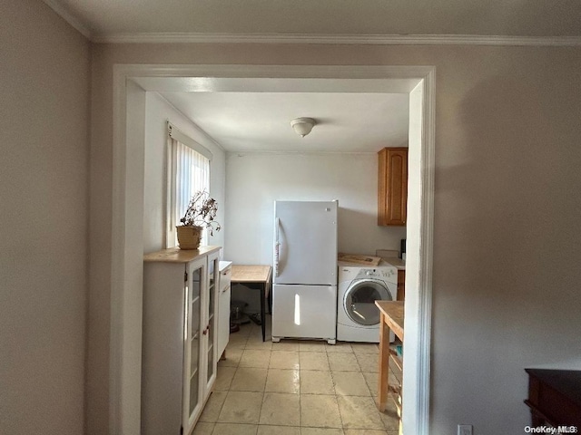 laundry area with cabinets, light tile patterned floors, washing machine and dryer, and ornamental molding