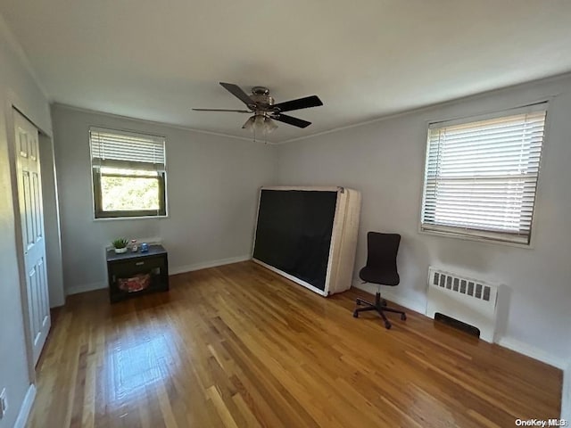 interior space with hardwood / wood-style flooring, a closet, radiator, and multiple windows