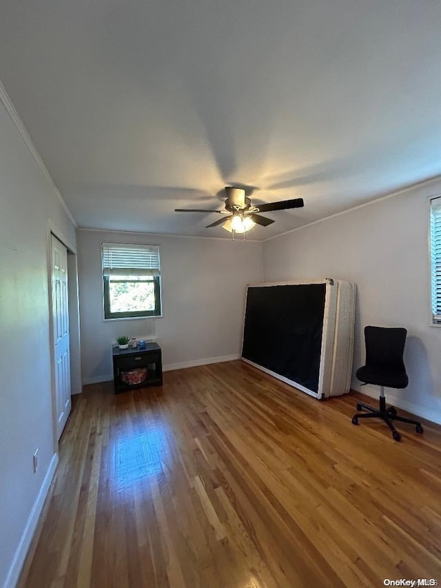 interior space featuring hardwood / wood-style floors, ceiling fan, and ornamental molding