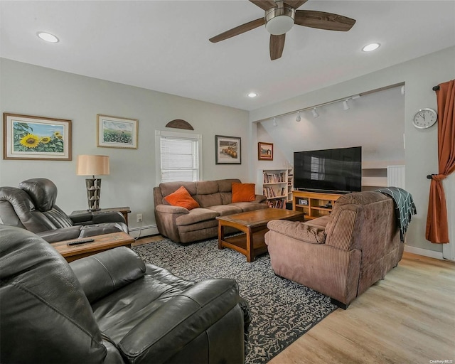 living room with light wood-type flooring, track lighting, baseboard heating, and ceiling fan