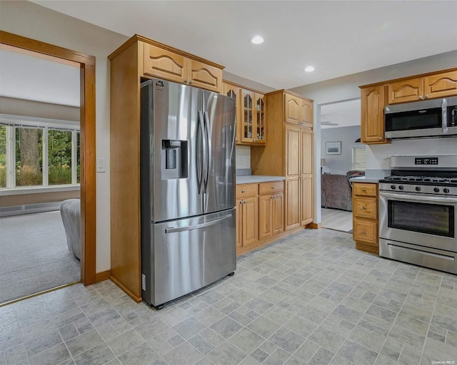 kitchen with light colored carpet and appliances with stainless steel finishes