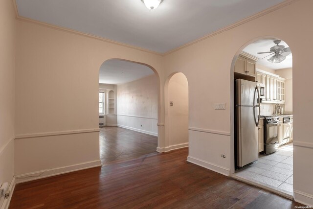 empty room with light hardwood / wood-style flooring, ceiling fan, and ornamental molding