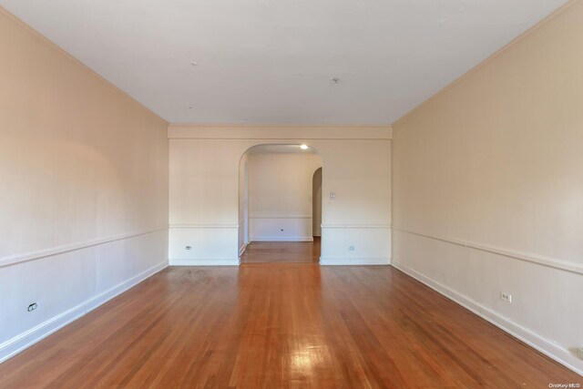 unfurnished room featuring hardwood / wood-style floors and ornamental molding