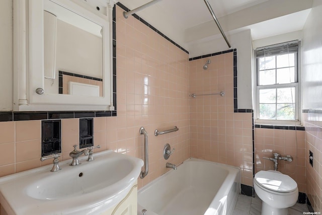 full bathroom with tiled shower / bath combo, tile patterned flooring, toilet, vanity, and tile walls