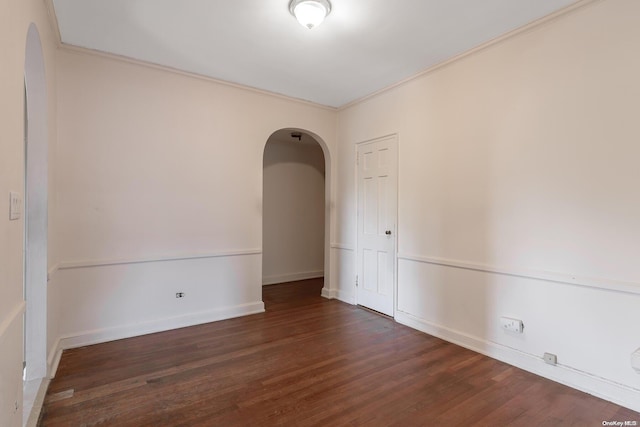 spare room featuring ornamental molding and dark wood-type flooring