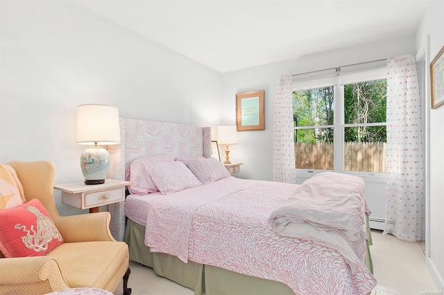 bedroom featuring light carpet and a baseboard heating unit