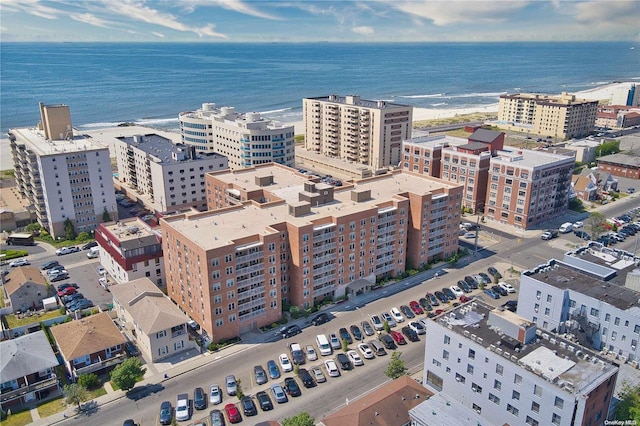 birds eye view of property with a water view and a beach view