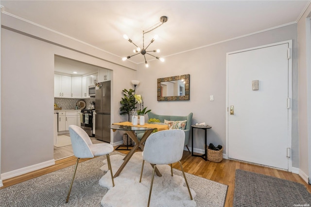 dining area with light wood-type flooring, ornamental molding, and an inviting chandelier