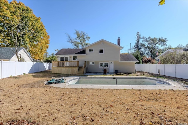 rear view of house featuring a swimming pool side deck and a lawn