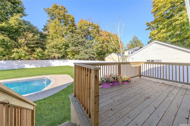 wooden terrace featuring a fenced in pool and a lawn