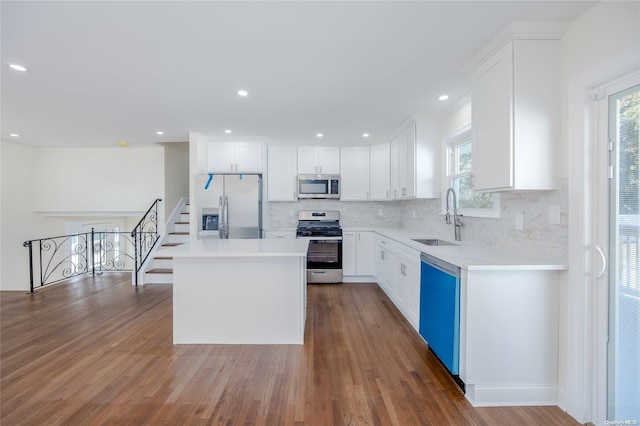 kitchen with white cabinets, a center island, dark hardwood / wood-style flooring, and stainless steel appliances