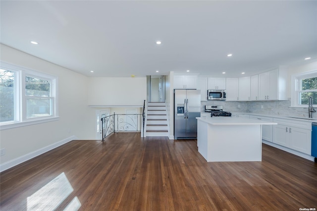 kitchen with a center island, sink, dark hardwood / wood-style floors, white cabinetry, and stainless steel appliances