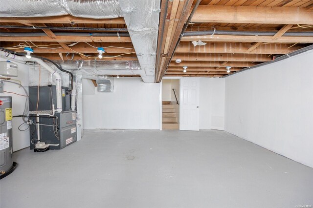 basement featuring heating unit and electric water heater