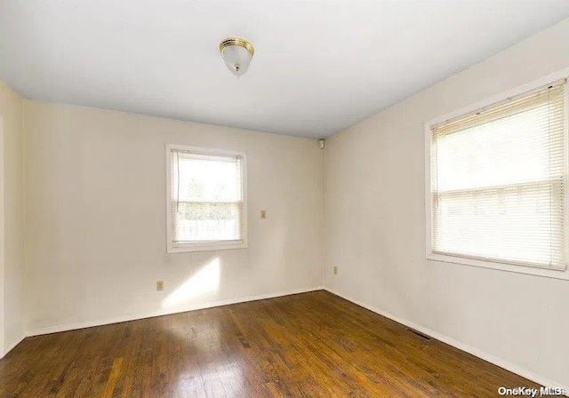 spare room featuring dark wood-type flooring