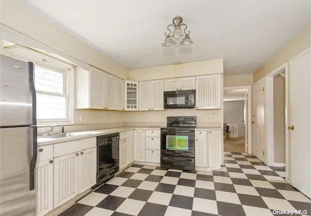 kitchen with sink, white cabinets, and black appliances