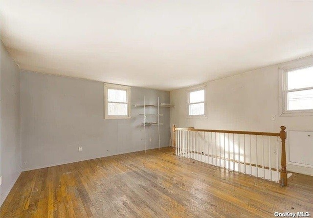 basement featuring plenty of natural light and light hardwood / wood-style floors