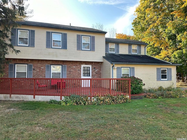 back of property with a yard and a wooden deck