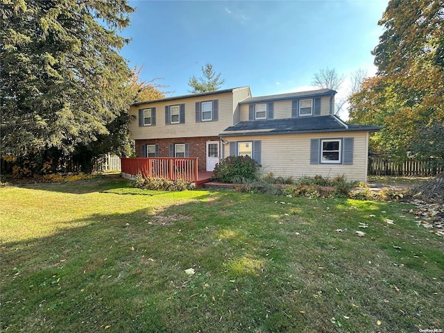 view of front of home with a deck and a front lawn