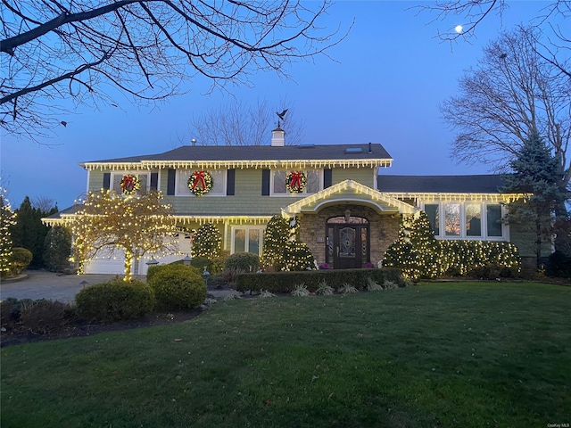 view of front of house with a yard and a garage