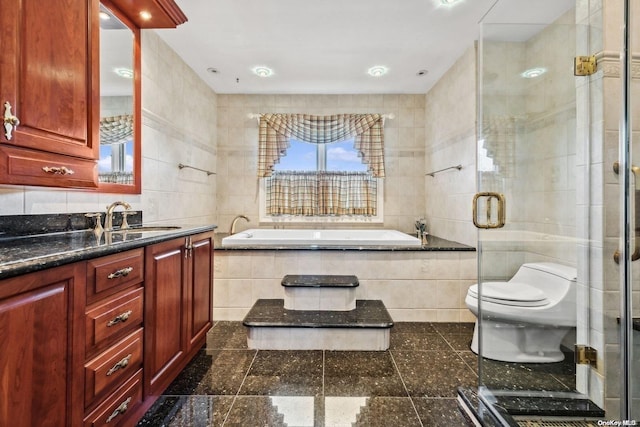 full bathroom with plus walk in shower, vanity, toilet, and tile walls