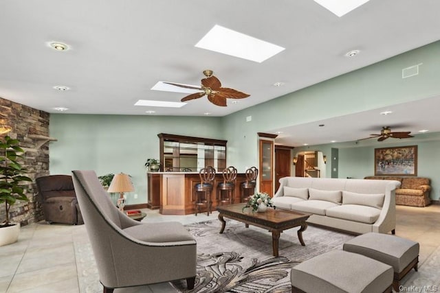 living room with bar, ceiling fan, light tile patterned flooring, and vaulted ceiling