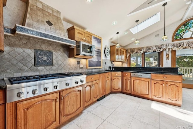 kitchen featuring stainless steel appliances, tasteful backsplash, decorative light fixtures, vaulted ceiling with skylight, and light tile patterned flooring