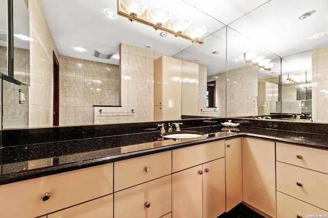 bathroom featuring vanity, tile walls, and walk in shower