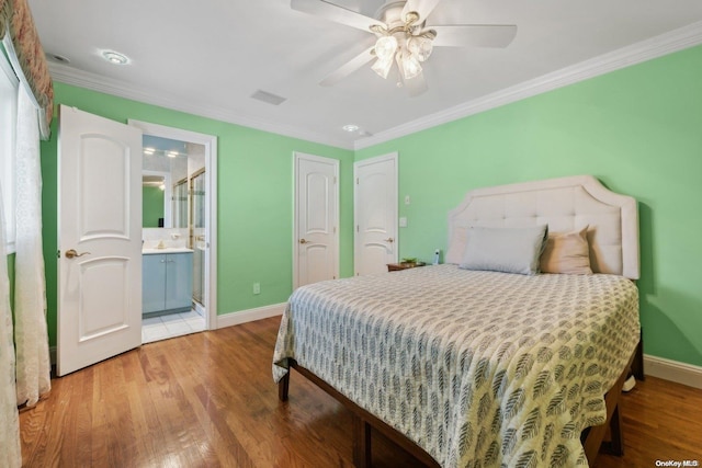 bedroom featuring ensuite bathroom, ceiling fan, wood-type flooring, and crown molding