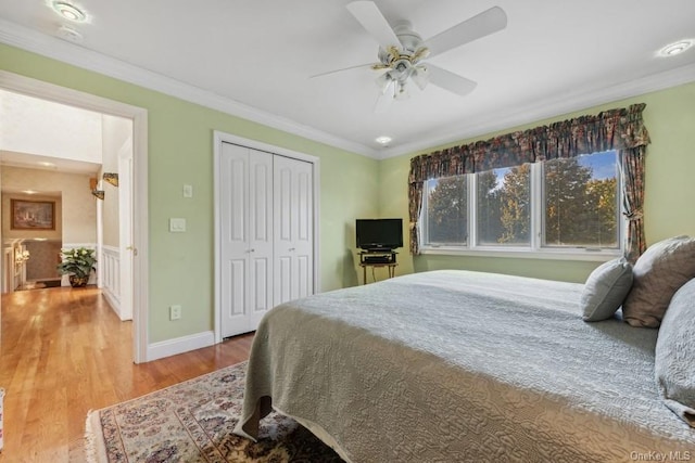 bedroom featuring ceiling fan, a closet, hardwood / wood-style flooring, and ornamental molding