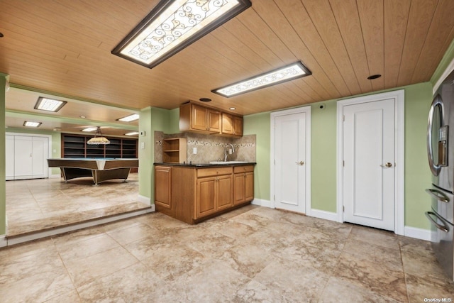 kitchen with tasteful backsplash, stainless steel fridge, sink, and wooden ceiling