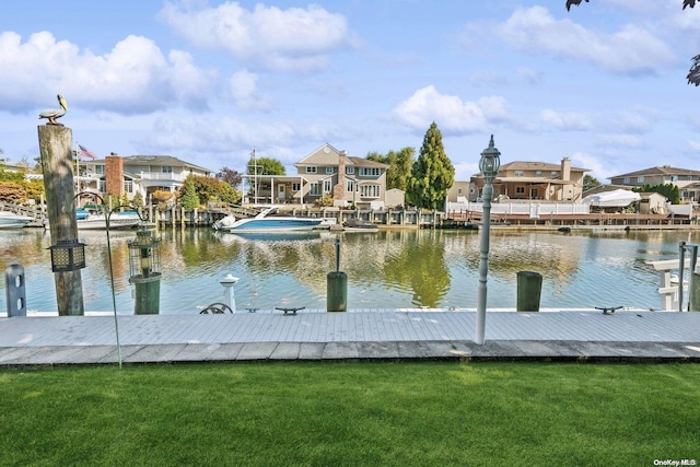 dock area with a water view and a yard