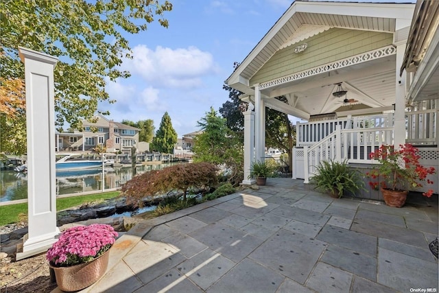 view of patio with ceiling fan and a water view