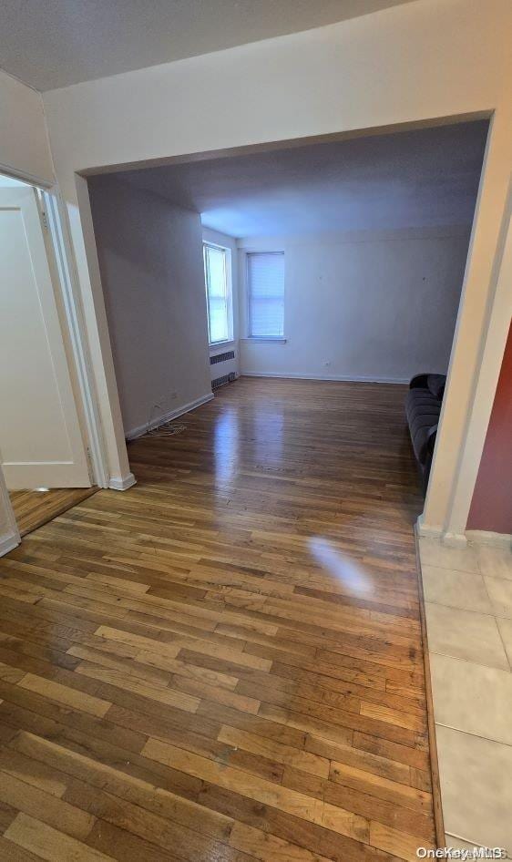 empty room with radiator and dark wood-type flooring