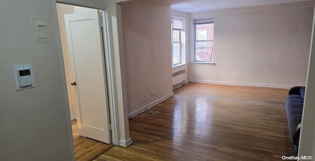 interior space featuring wood-type flooring and radiator heating unit