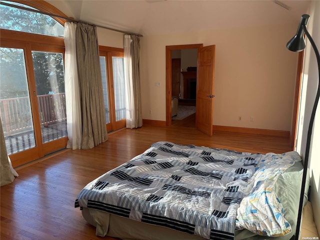 bedroom featuring access to exterior and wood-type flooring