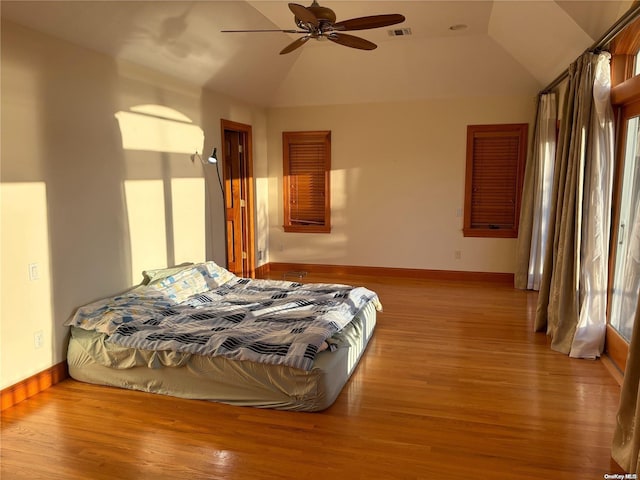 bedroom with light wood-type flooring, vaulted ceiling, and ceiling fan