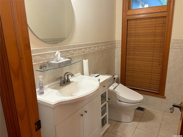 bathroom with tile patterned flooring, vanity, toilet, and tile walls