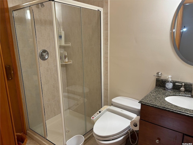 bathroom with vanity, toilet, and a shower with door