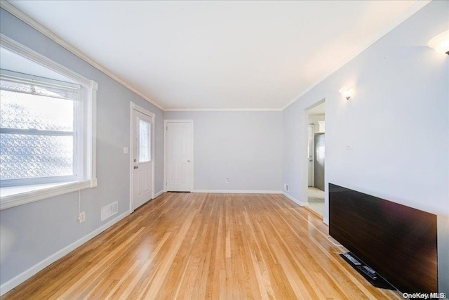 unfurnished living room with light hardwood / wood-style flooring and crown molding