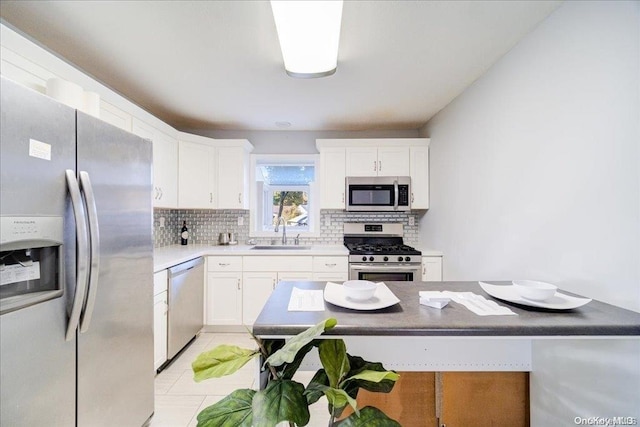 kitchen featuring white cabinets, sink, light tile patterned floors, appliances with stainless steel finishes, and tasteful backsplash