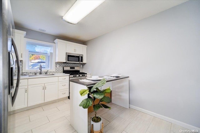 kitchen featuring white cabinets, sink, appliances with stainless steel finishes, and tasteful backsplash