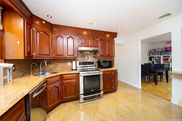 kitchen featuring light stone countertops, stainless steel appliances, tasteful backsplash, and sink