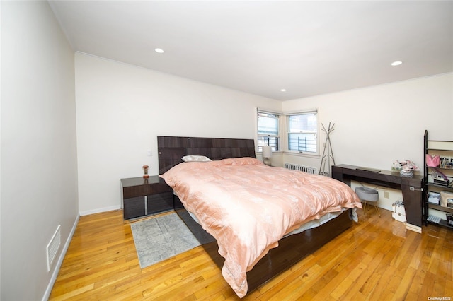 bedroom with radiator and light hardwood / wood-style flooring