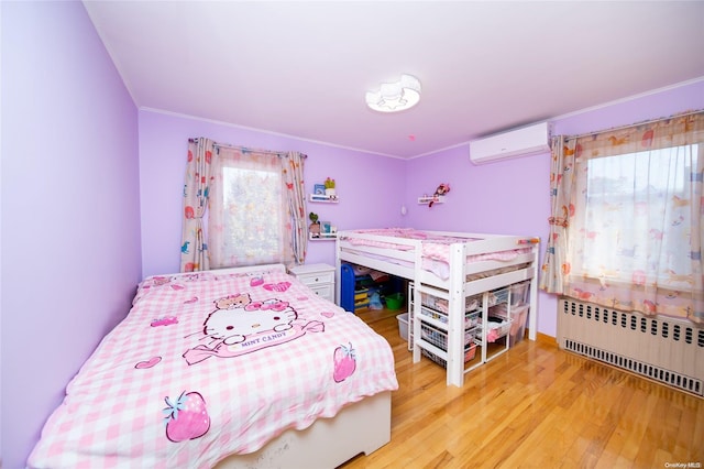 bedroom featuring radiator heating unit, light hardwood / wood-style floors, a wall unit AC, and ornamental molding