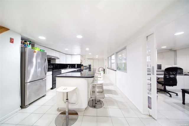 kitchen with electric stove, exhaust hood, a center island, white cabinetry, and stainless steel refrigerator