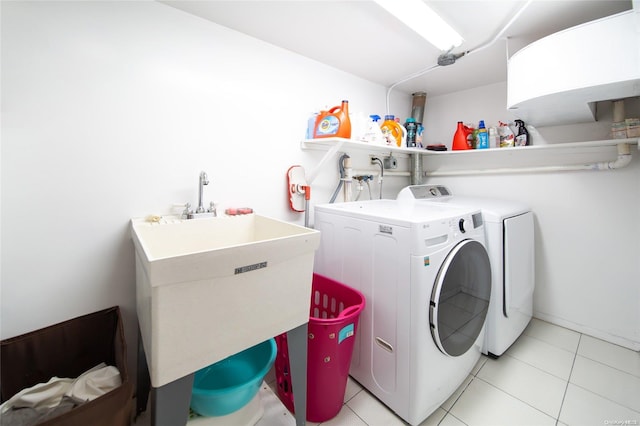 laundry room with light tile patterned flooring, independent washer and dryer, and sink